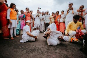 Vibrant group participating in a traditional Indian festival with colorful attire and lively dance performance.